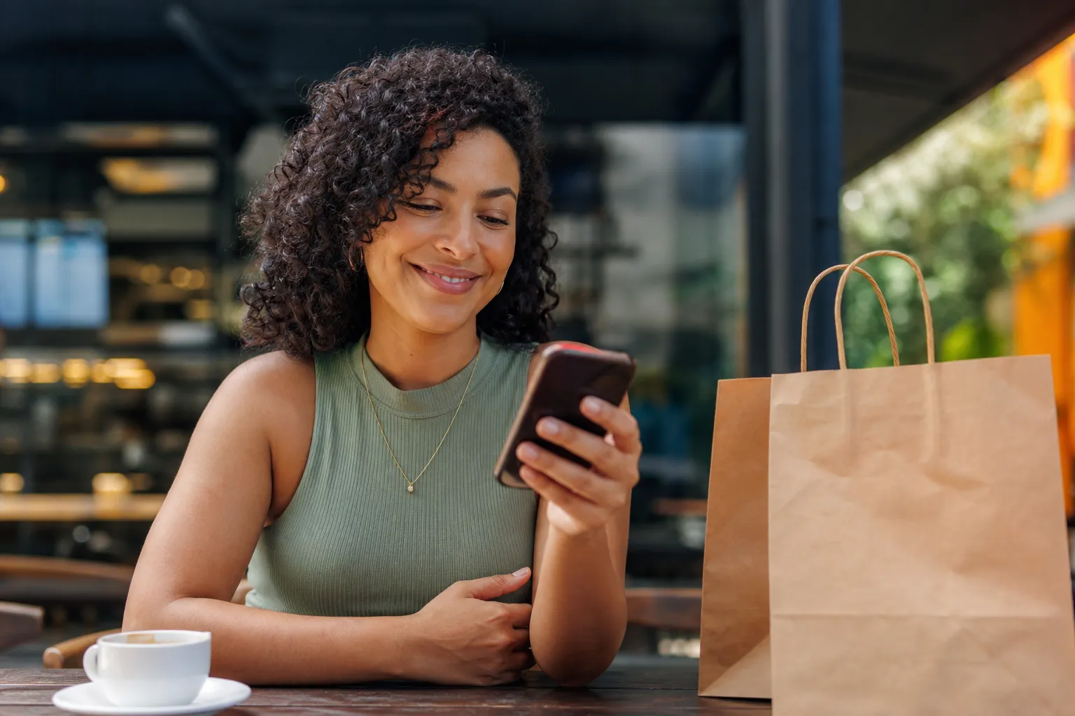 Cliente recebendo no celular a confirmação do pedido enquanto toma café